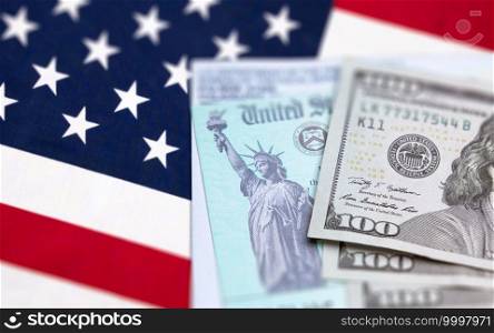 United States IRS Check, Envelope and Money Resting on American Flag.