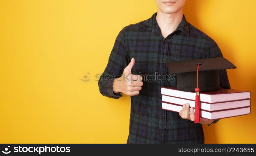 University man is happy with graduation on yellow background