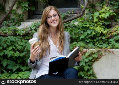 University student reading a book and enjoying a beverage