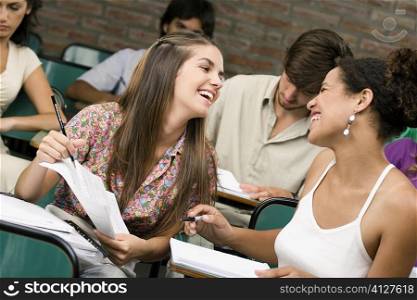 University students sitting in a classroom and smiling