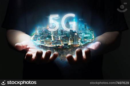 Unknown hand holding fantasy island floating in the air with 5G network wireless systems , Smart city and communication network concept .