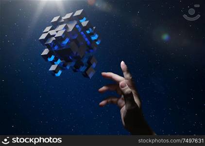 Unknown hand touching floating blue shiny cube on dark background .