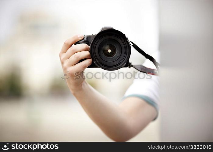 unknown paparazzi or stringer with professional camera,natural light, selective focus on camera lens