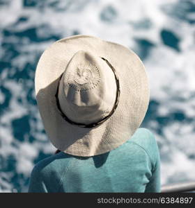 unknown woman with hat looking at the ocean like vacation concept