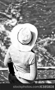 unknown woman with hat looking at the ocean like vacation concept