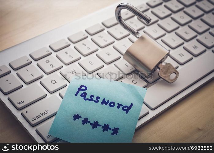 Unlock padlock with word SAFE on key and secret password paper note on white keyboard, dark dim light. Digital data, encryption, online banking, cyber security, business solution, future innovation.