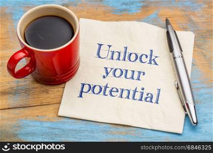 Unlock your potential reminder - handwriting on a napkin with a cup of coffee