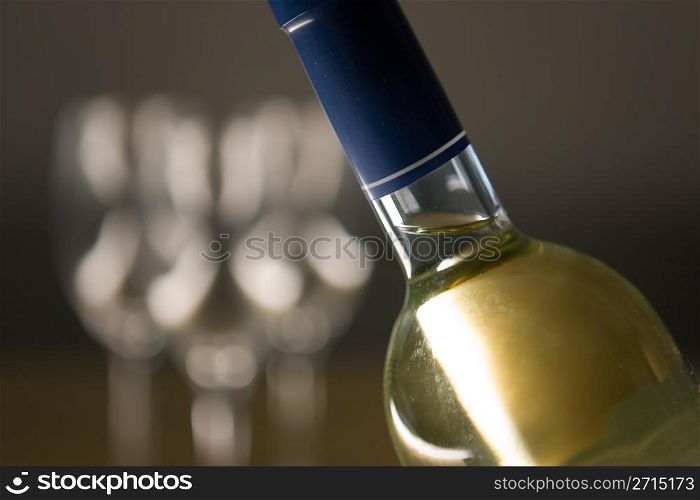 Unopened wine bottle and glasses on a wooden table