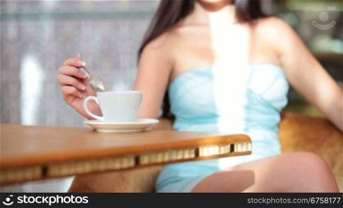 Unrecognisable Young woman drinking coffee in coffee shop