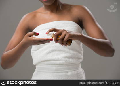 Unrecognizable african woman applying cream . Skincare concept