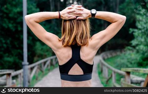 Unrecognizable athlete woman doing stretching arms outdoors