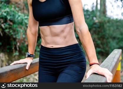 Unrecognizable athlete woman training on parallel bars in a park. Athlete woman training on parallel bars