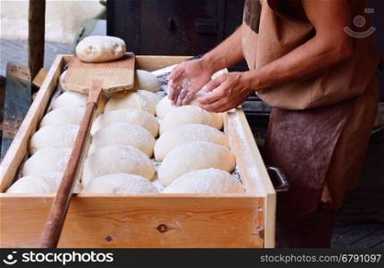 Unrecognizable baker sprinkle bread dough with flour
