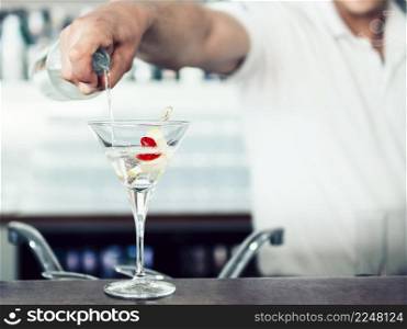 unrecognizable barman pouring cocktail glass
