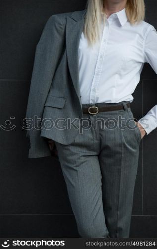 Unrecognizable business woman leaning on wall