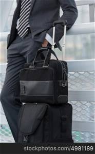 Unrecognizable businessman in urban environment of airport with suitcase