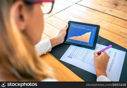 Unrecognizable businesswoman analyzing market evolution with tablet
