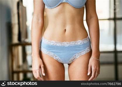 Unrecognizable caucasian female with a beautiful belly wearing blue lingerie. Unrecognizable female with a beautiful belly wearing blue lingerie