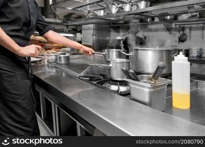 Unrecognizable Chef cooking in modern industrial kitchen. High quality photo. Unrecognizable Chef cooking in modern industrial kitchen.