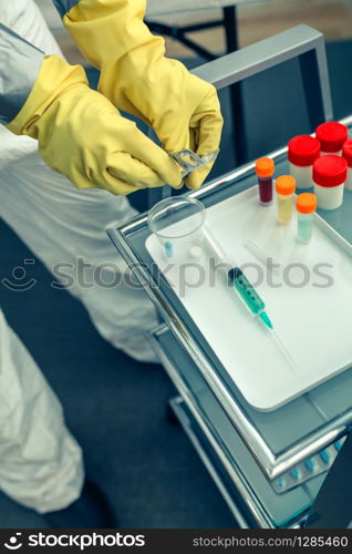 Unrecognizable doctor preparing dose of medication for a patient