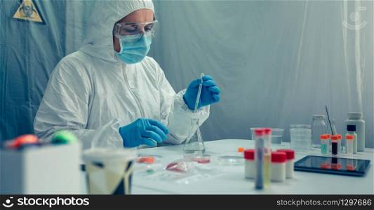Unrecognizable female scientist with bacteriological protection suit doing research in the laboratory