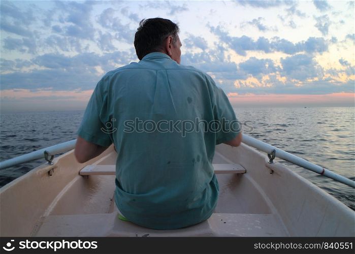 unrecognizable man on oars rowing boat rear view