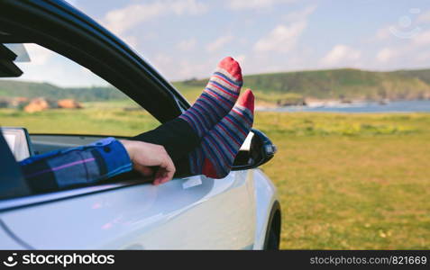 Unrecognizable man resting with his feet up sitting on the passenger seat of the car. Unrecognizable man resting feet up sitting on the car