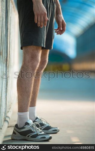Unrecognizable man with athletic pair of legs going for jog or run during sunrise or sunset - healthy lifestyle concept