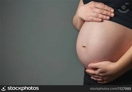 Unrecognizable pregnant woman caressing her belly