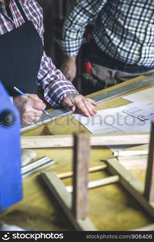 Unrecognizable senior couple working in a carpentry workshop. Unrecognizable senior couple in a carpentry