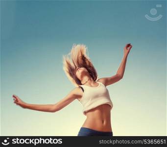 Unrecognizable shot of the blonde teenager girl jumping happy with the blue sky in the background