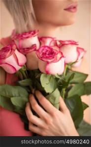 Unrecognizable woman holding bouquet of pink roses. She is very satisfacted. Valentine's day or international women's day celebration.