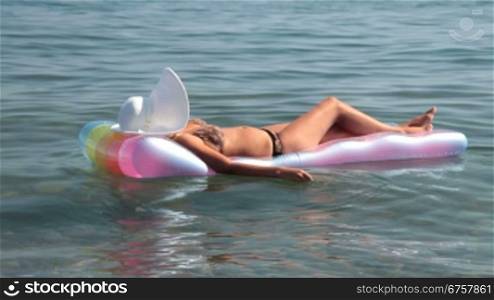 unrecognizable woman in bikini relaxing on raft