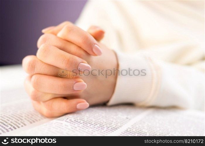 Unrecognizable woman reading big book - Holy Bible and praying. Christian studying scripture. Student in the college library preparing for exams. Learning, gratitude, religion concept. Unrecognizable woman reading big book - Holy Bible and praying. Christian studying scripture. Student in the college library preparing for exams. Learning, gratitude, religion concept.