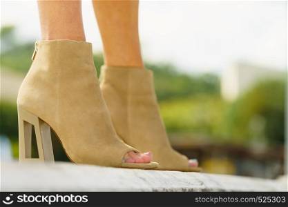 Unrecognizable woman wearing suede high heels with open toes. Fashionable outfit accessories details conept.. Woman wearing suede brown high heels