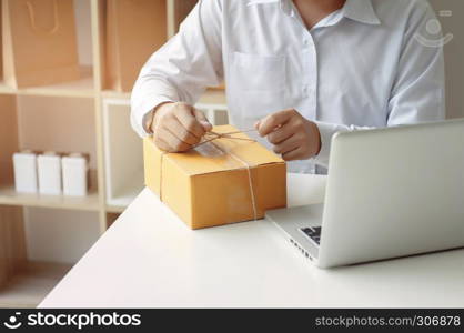 unrecognized seller person packing, box package in a store.