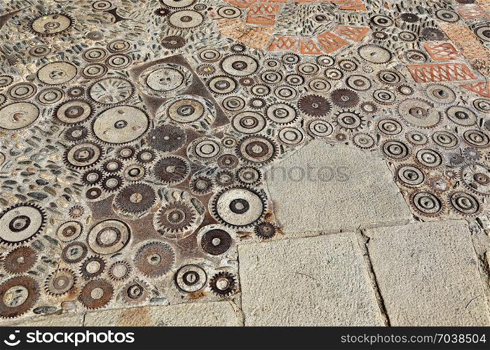 Unusual floor with pattern from pebbles, brick and rusty metal details in the park Montjuic, Barcelona, Catalonia, Spain