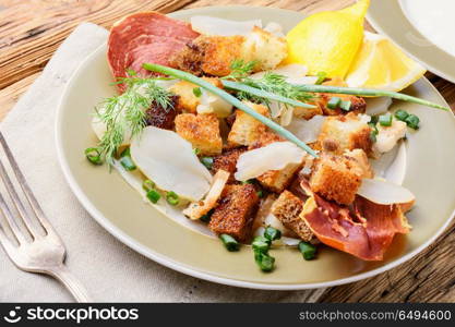 Unusual meat salad. Salad with fried bacon, croutons and Jerusalem artichoke