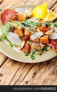 Unusual meat salad. Salad with fried bacon, croutons and Jerusalem artichoke