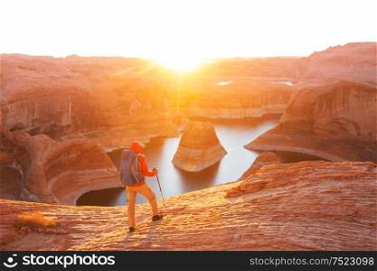 Unusual natural background. Reflection Canyon on Lake Powell, Utah, USA. Inspiring hiking scene-man resting on the beautiful sunset point.