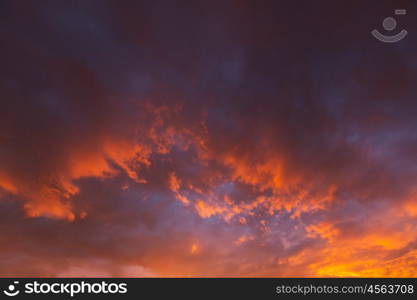 Unusual storm clouds at sunset. Bright red and orange colors of the sky. Suitable for background.