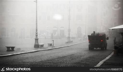 Unusual view of Piazza navona wrapped in fog with a garbage truck moving