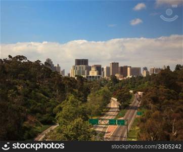 Unusual view of San Diego skyline off Cabrillo bridge from Balboa Park over empty interstate highway
