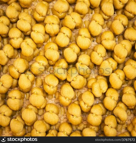 Unusual yellow background of fabric twisted into balls