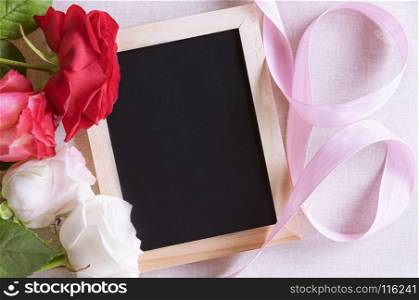 Unwritten chalkboard surrounded by beautiful colorful roses and a pink ribbon. Perfect frame for birthdays, mother day and valentine day.