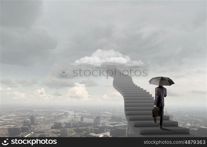 Up the career ladder. Businessman holding umbrella and waking on career ladder