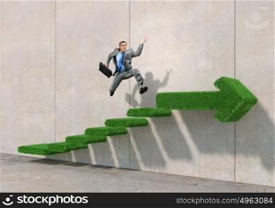 Up the career ladder. Businessman with suitcase running on green grass staircase