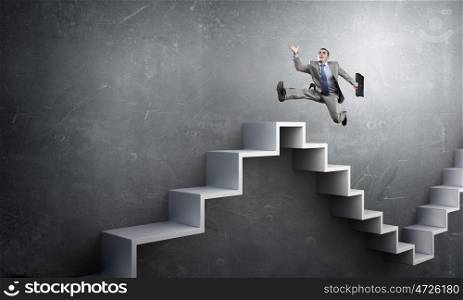 Up the career ladder. Businessman with suitcase running on stone staircase