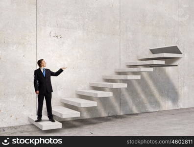 Up the career ladder. Businessman with suitcase standing on stone staircase