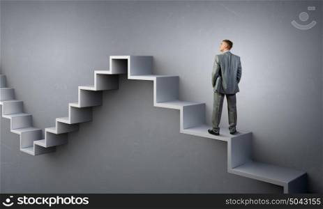 Up the career ladder. Businessman with suitcase standing on stone staircase